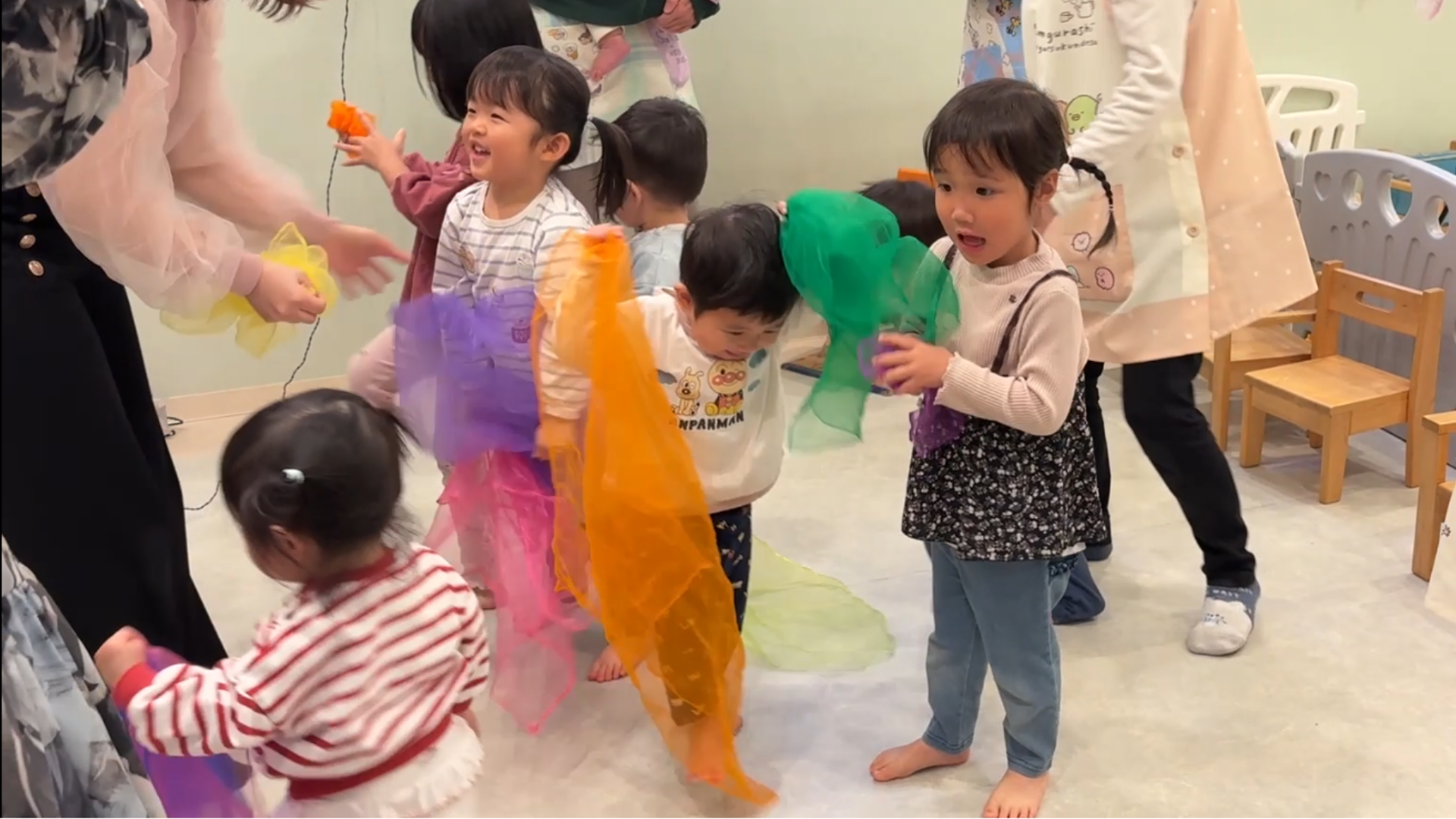 リトミックスカーフを手に体を動かす子供たち